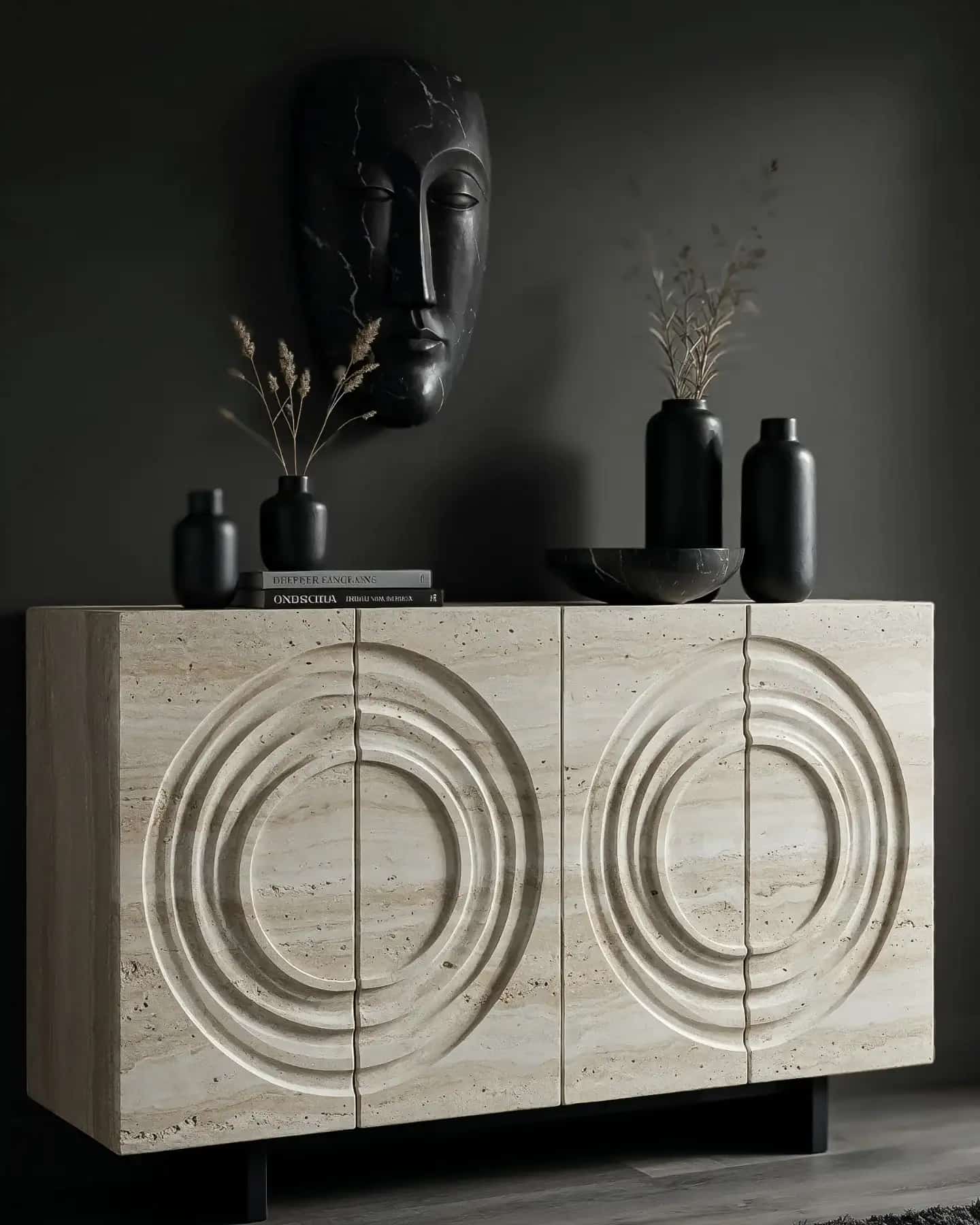 A wooden sideboard fully clad in travertine with hand-carved concentric-circle doors