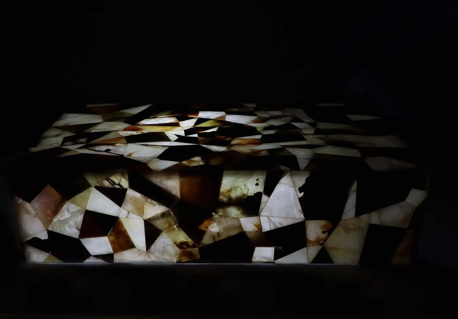 A backlit coffee table with a mosaic of earthy translucent marble