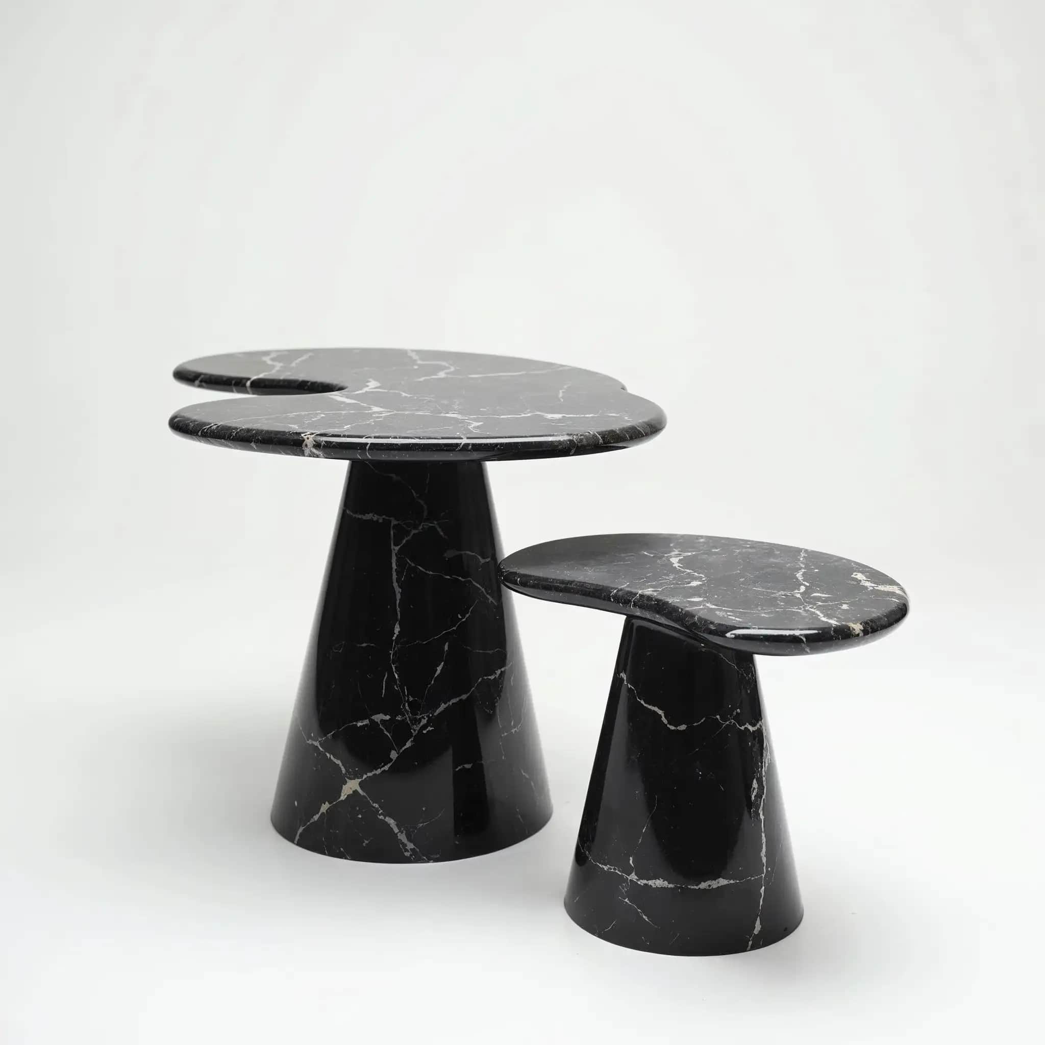 A pair of Nero Marquina side tables with asymmetric tops on conical bases