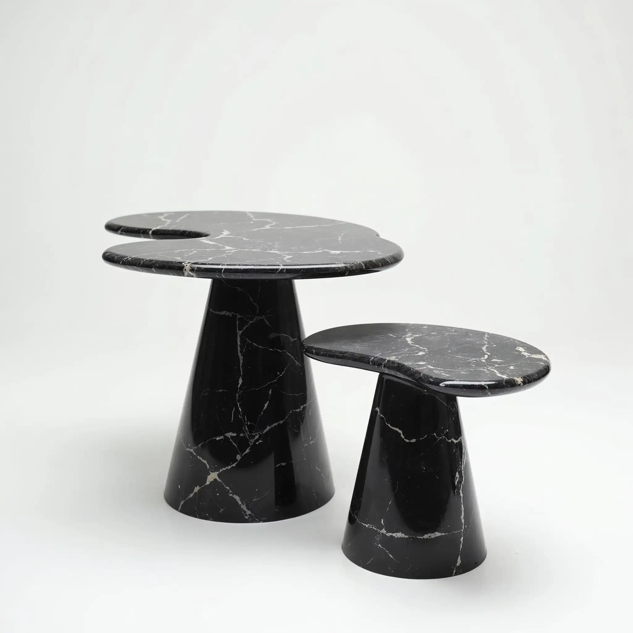 A pair of Nero Marquina side tables with asymmetric tops on conical bases